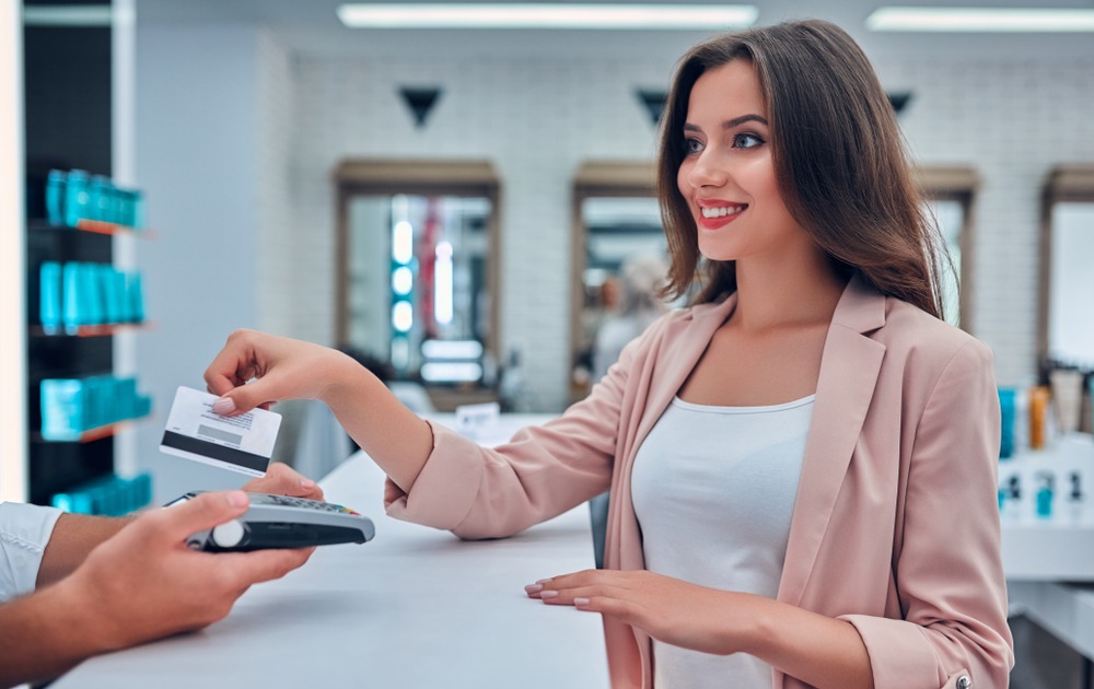 Woman paying with her bankcard at the counter of a beauty salon